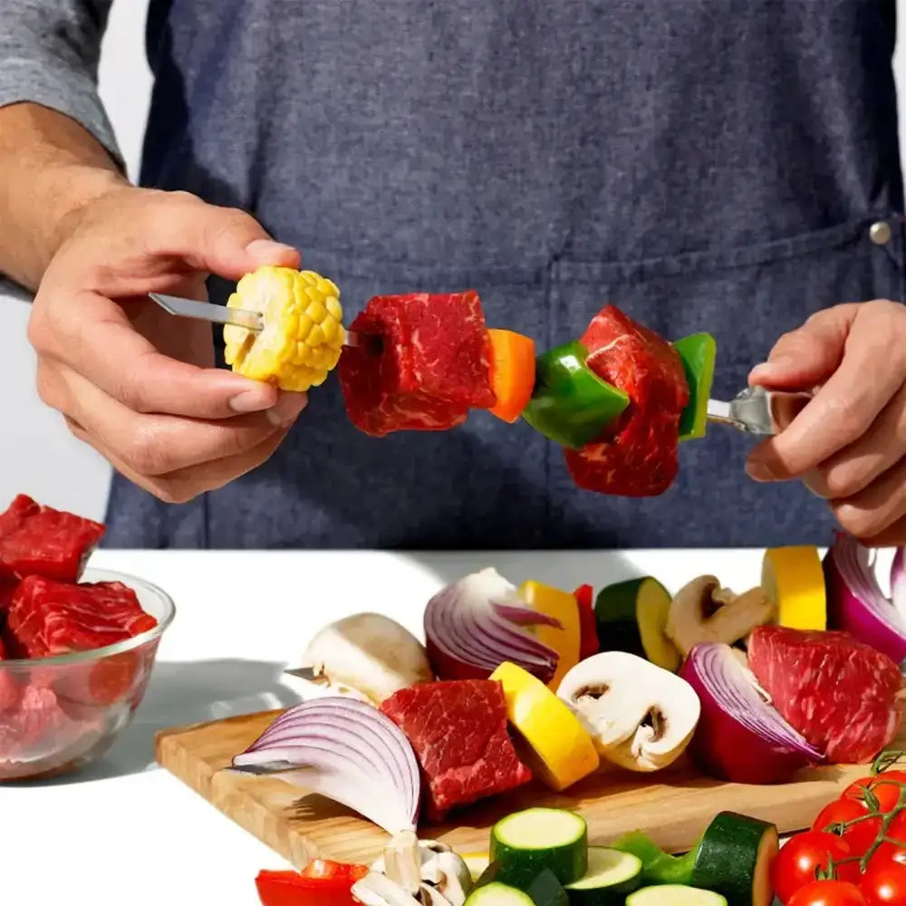 Person preparing a skewer with vegetables on a cutting board