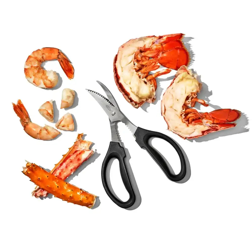 Shrimp and lobster claws with a pair of kitchen shears on a white background