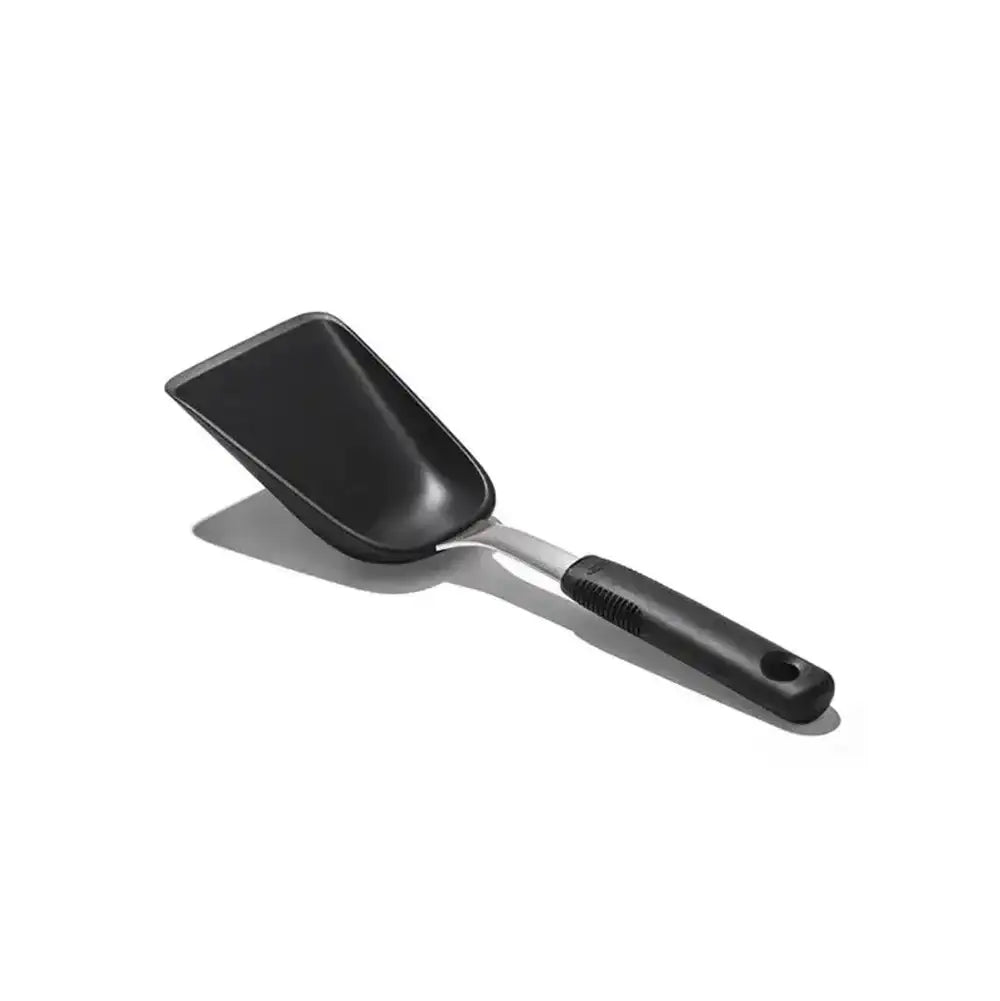 Black frying pan with a spatula on a white background