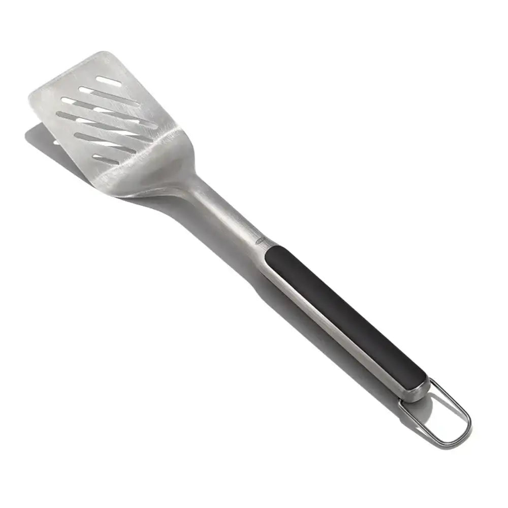 White slotted spatula with black handle on a white background