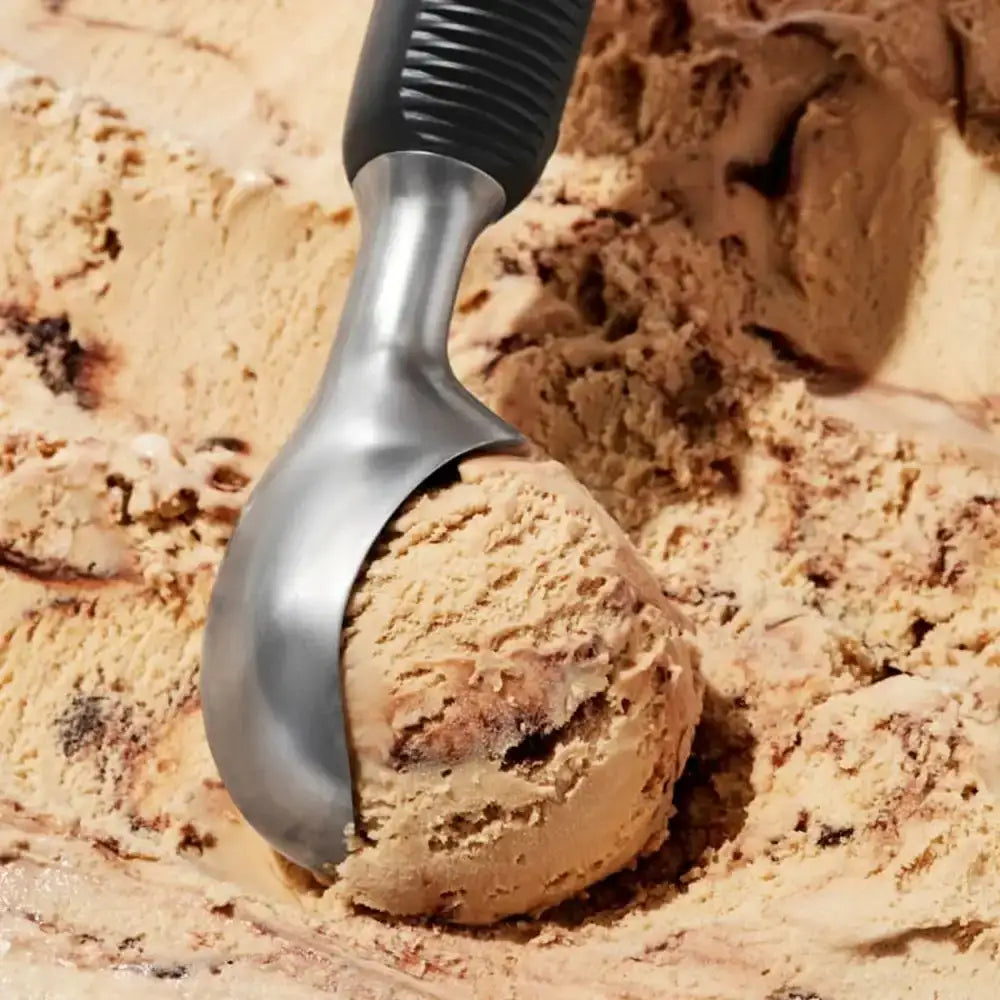 Ice cream scoop with cookie dough ice cream on a bed of cookie dough