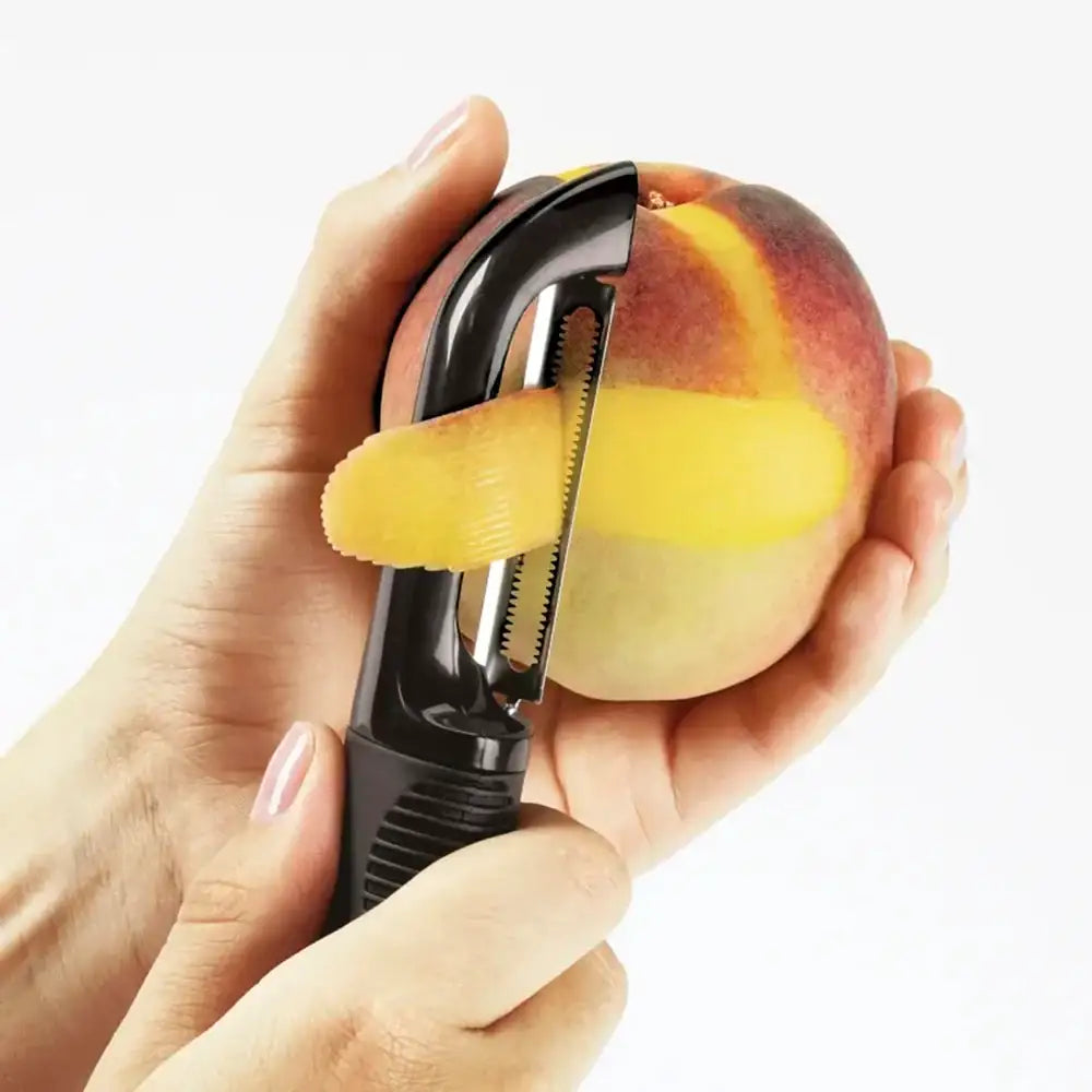 Hand using a peach peeler to remove skin from a peach on a white background
