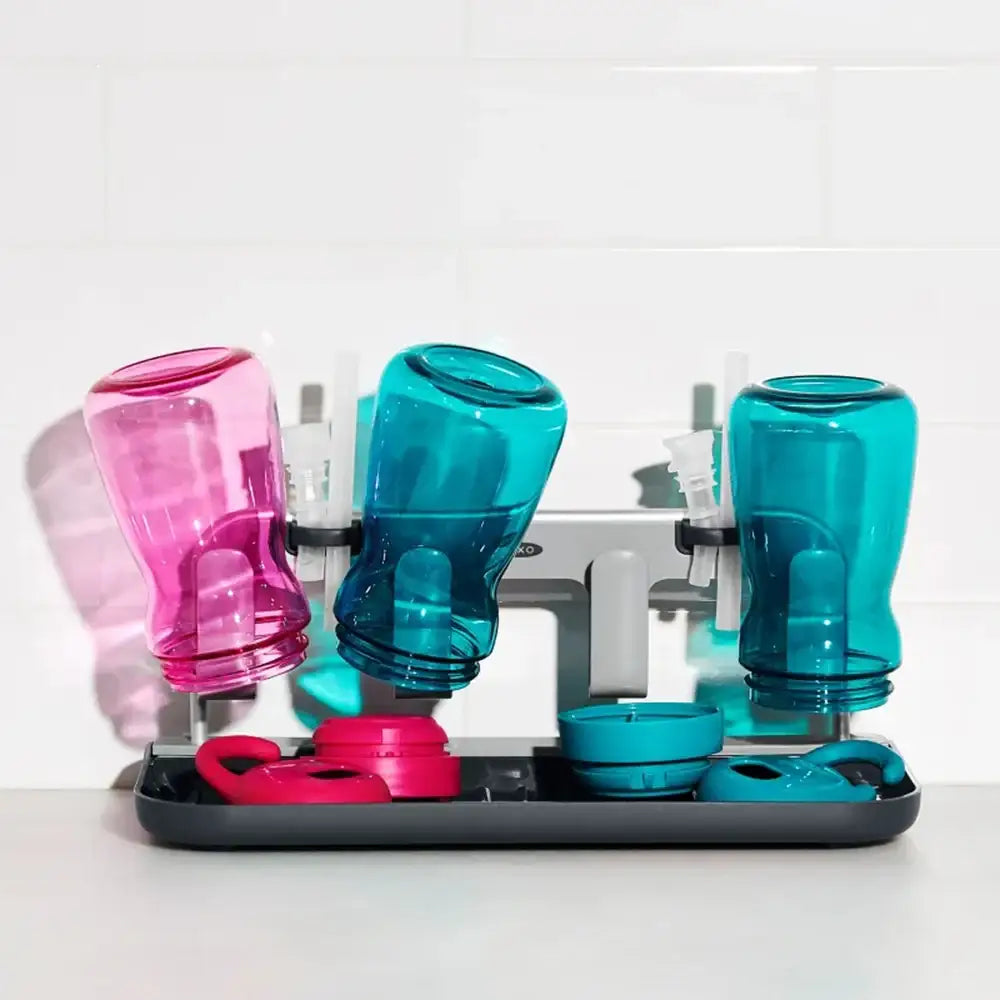 Colorful pet water bottles and bowls on a stand with a white background