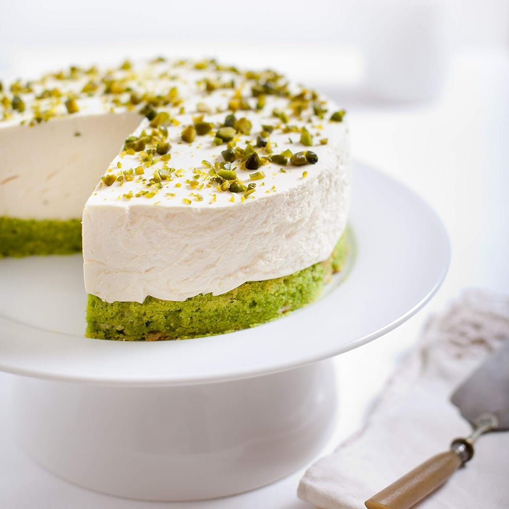 Two-layered cake with green and white layers on a white cake stand.