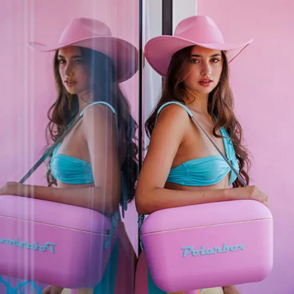 Woman holding a pink and purple case with 'Polaroid' branding against a pink background