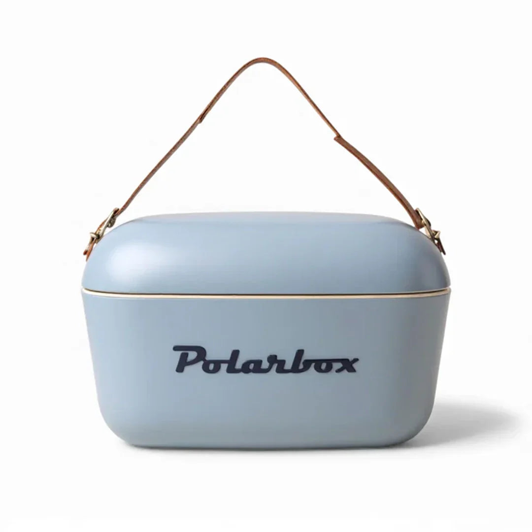 A light blue Polarbox cooler bag with a brown leather handle and gold trim, featuring the Polarbox logo on the front, set against a plain white background.