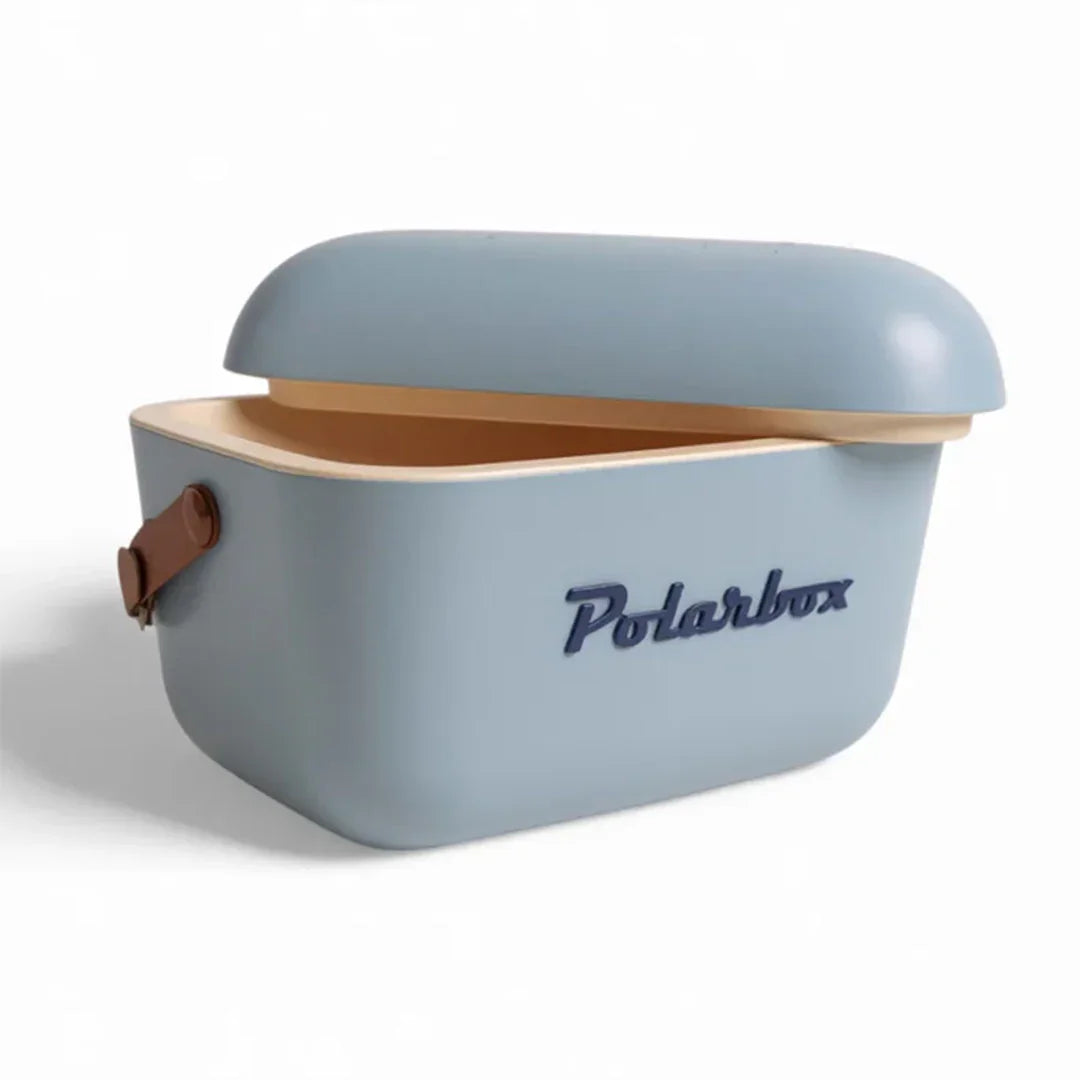 A light blue Polarbox cooler with its lid slightly open, showing a tan interior and a brown handle, on a clean white background.