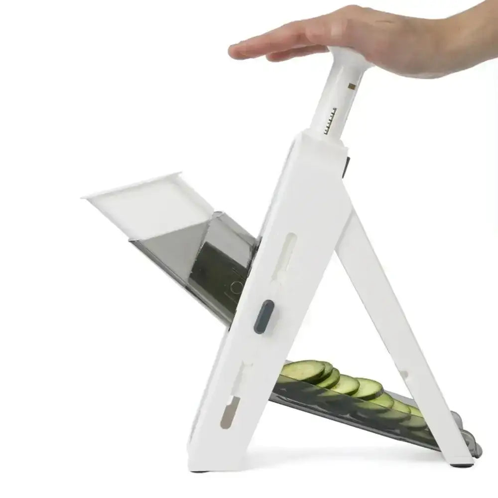 White vegetable slicer with sliced cucumbers on a white background