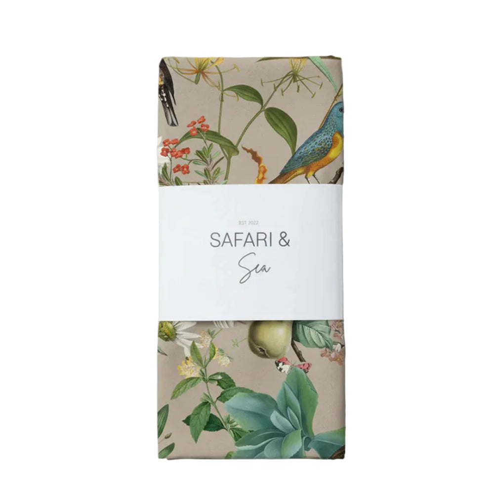 Product packaging with floral and bird design on a beige background