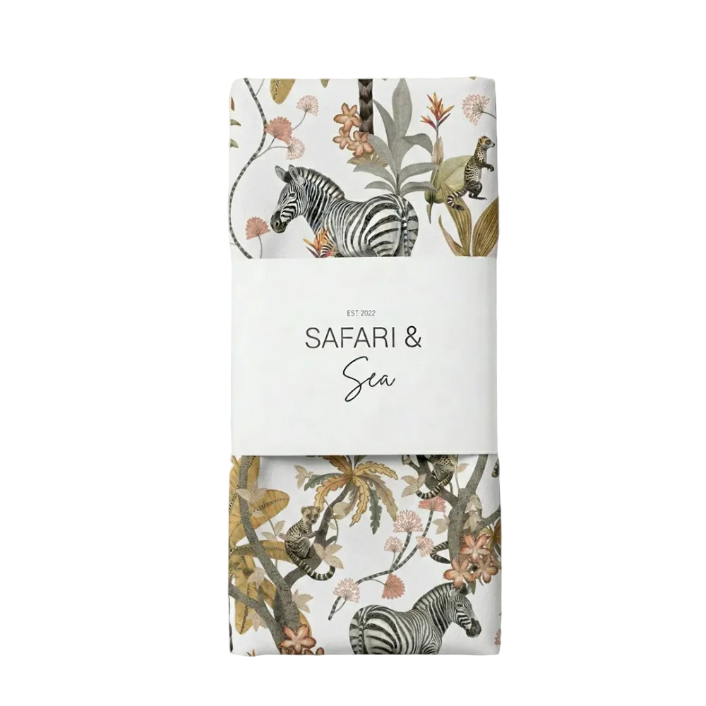 A folded textile product wrapped in a white paper band reading 'SAFARI & Sea' with small 'EST. 2022' above it.