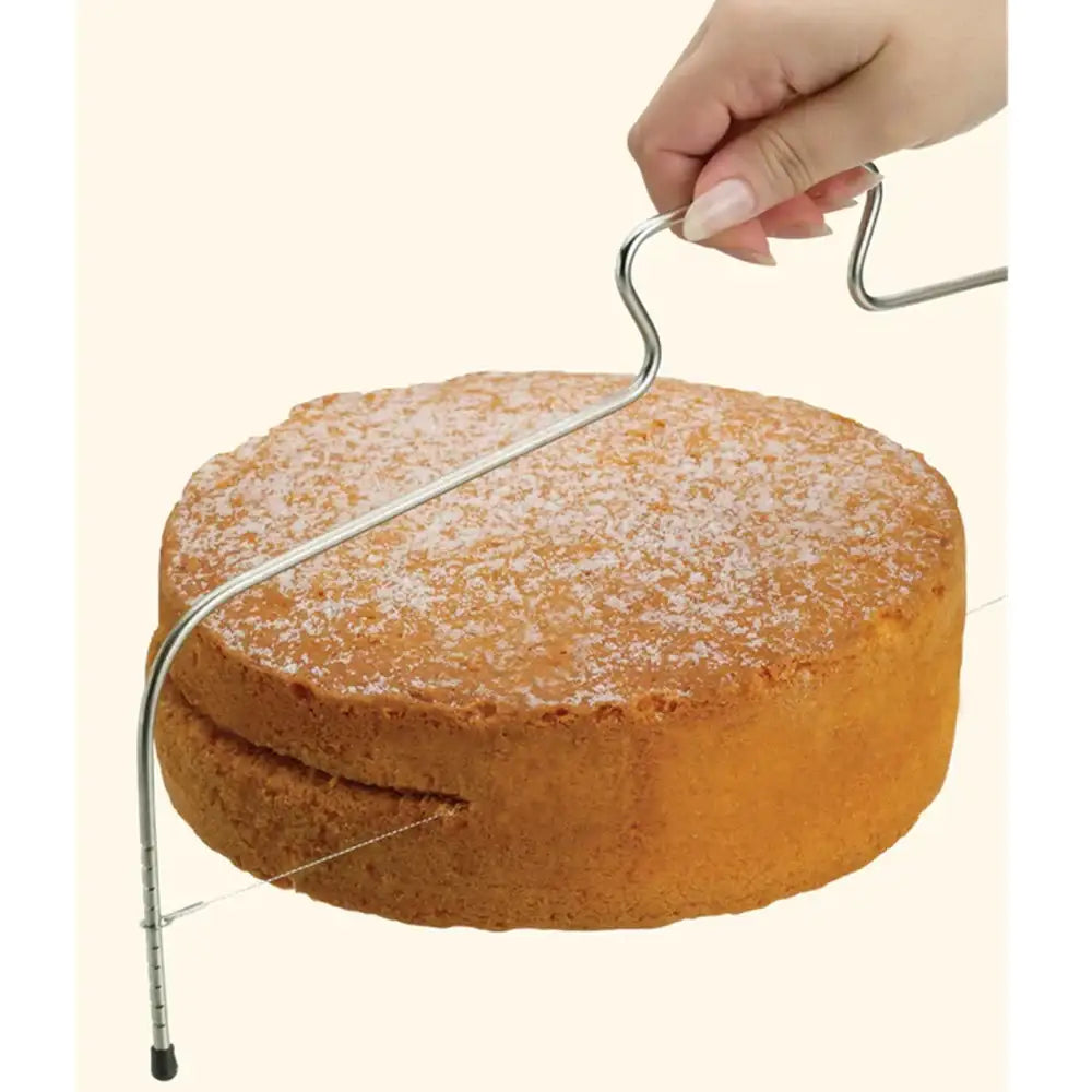 Round cake with a metal cake cutting wire on a beige background