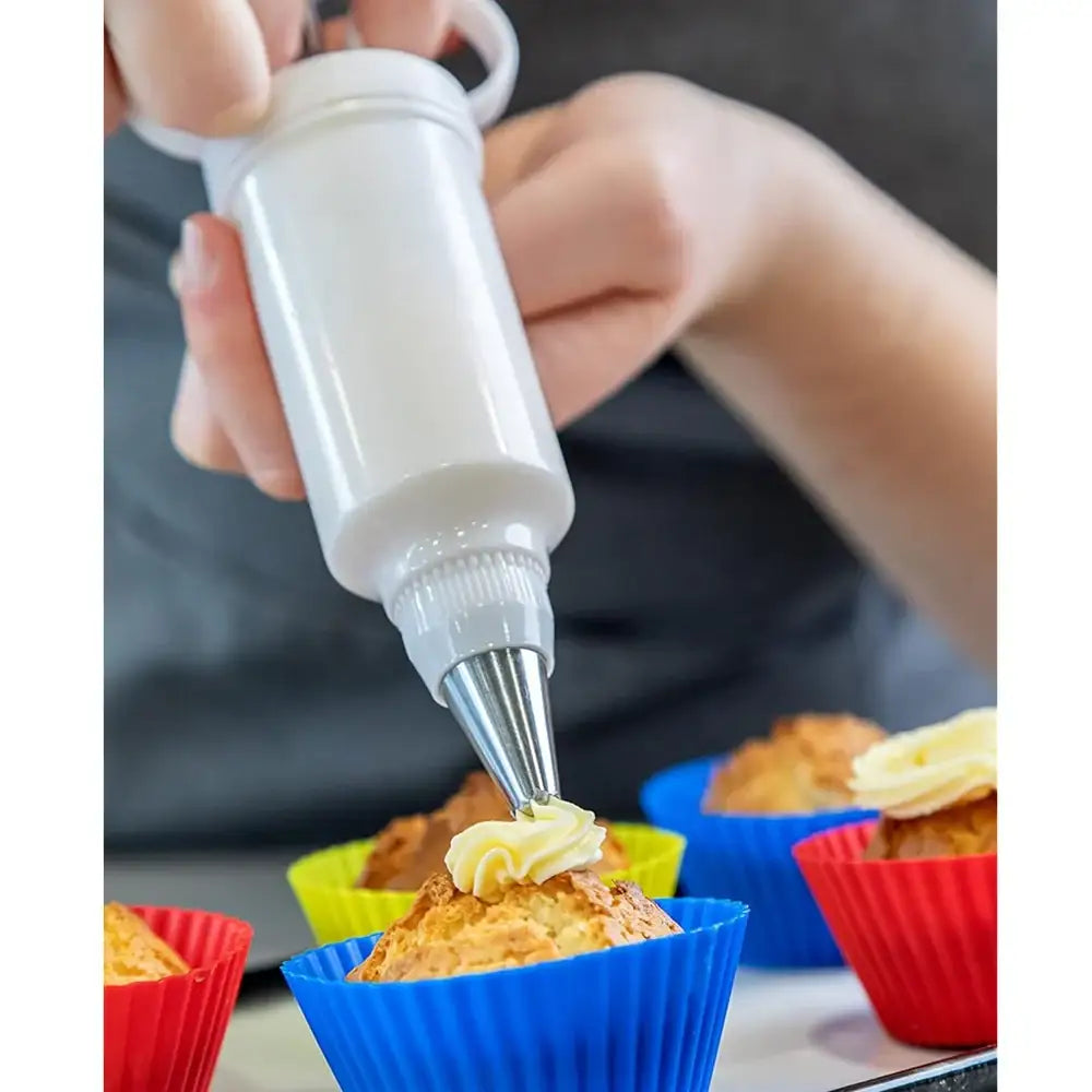 Person frosting cupcakes with a piping bag in colorful silicone cupcake liners.
