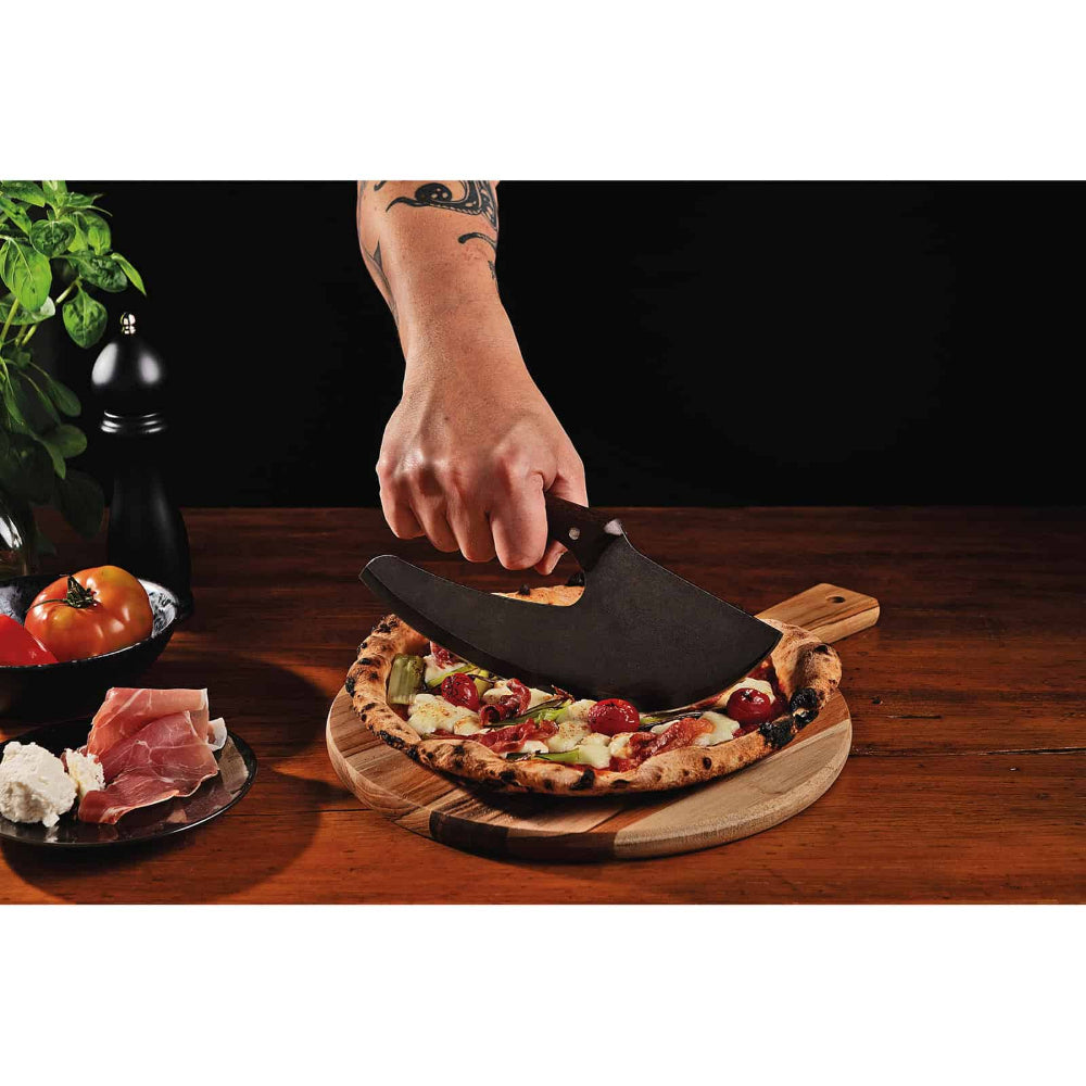 Person using a pizza cutter on a pizza with various toppings on a wooden board.