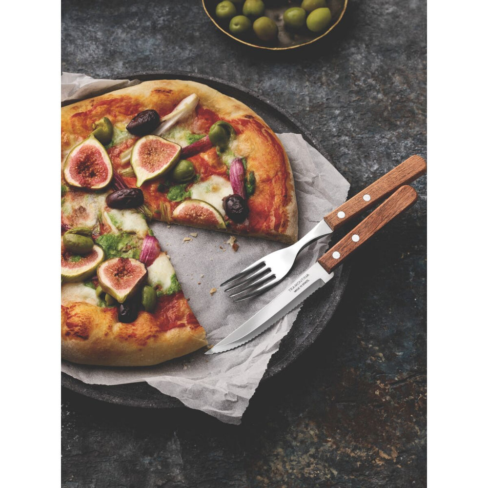 Artisanal style pizza with a knife and fork set beside it on a dark grey surface.