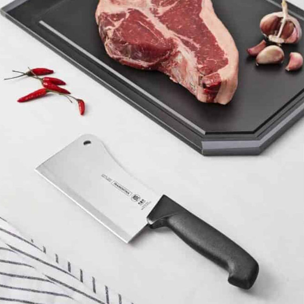 Raw steak on a cutting board with a cleaver knife and garlic cloves on a white background