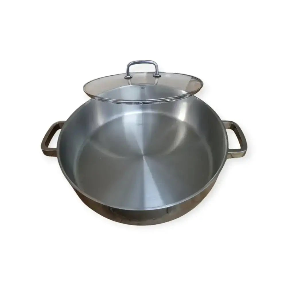 Stainless steel wok with lid on a white background