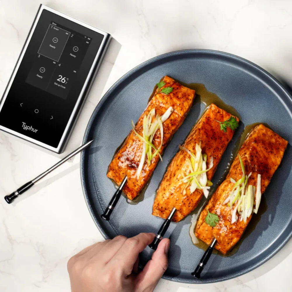 Three pieces of cooked salmon with a hand holding a thermometer probe on a white background.