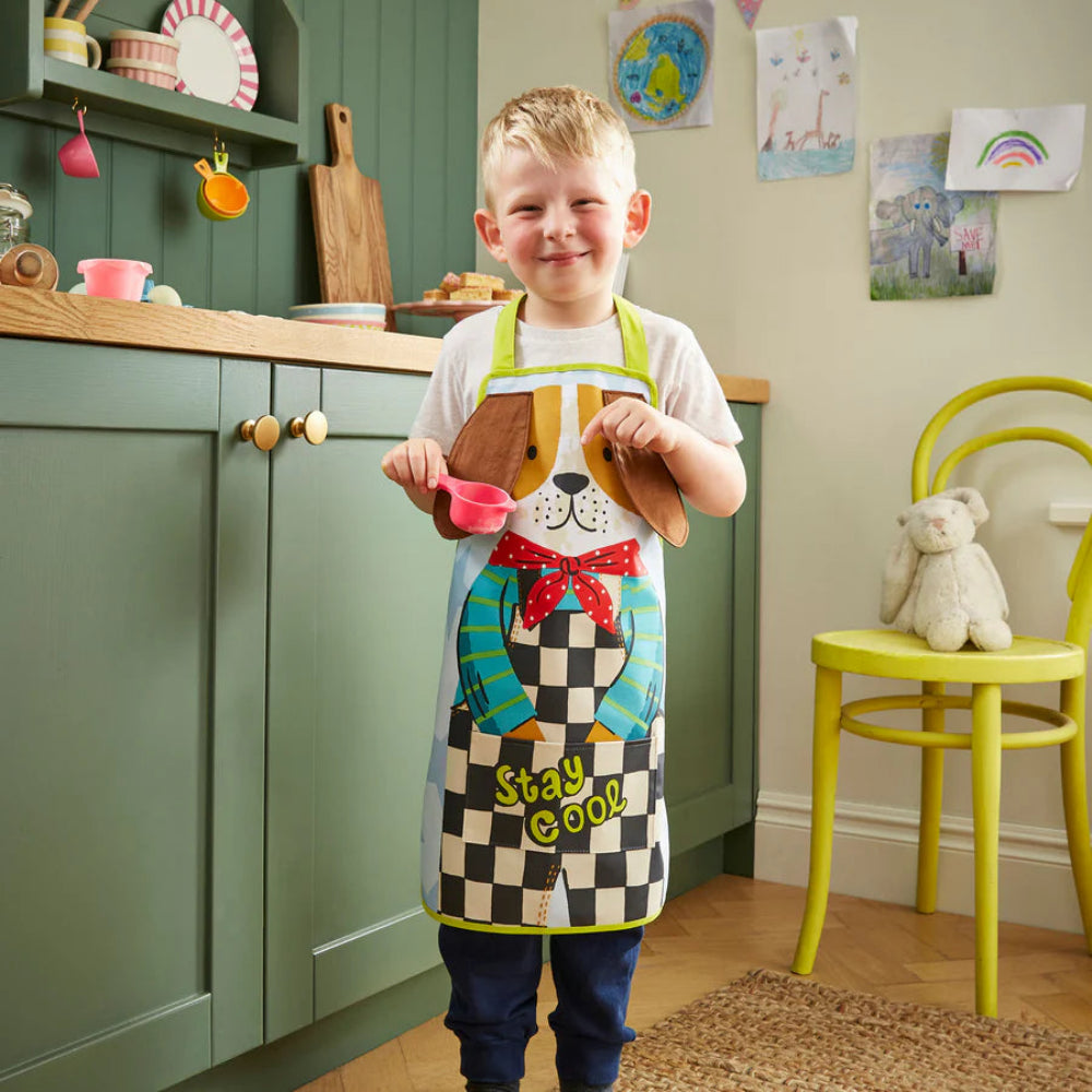 Child wearing a colorful apron in a kitchen setting