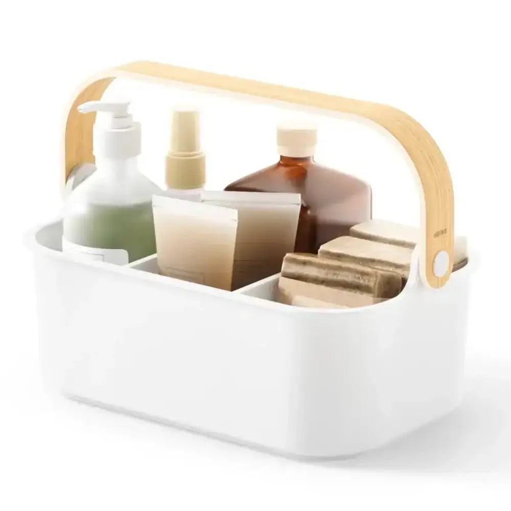 White caddy with wooden handle holding various skincare products on a white background
