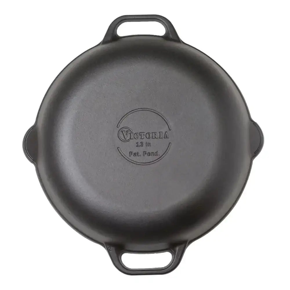 Black cast iron skillet with 'Victoria' branding on a white background