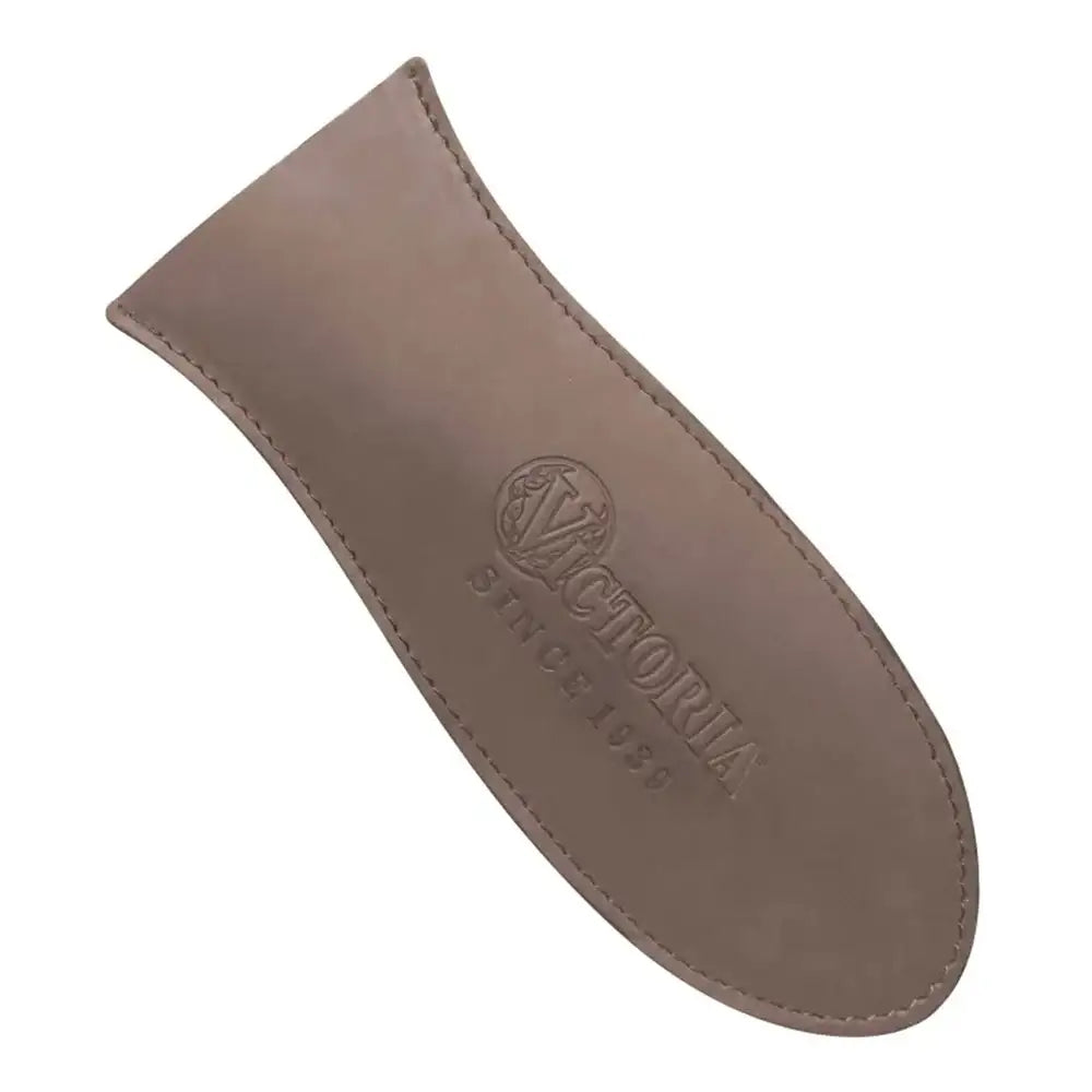 Brown leather skillet handle cover with 'Victoria' branding on a white background