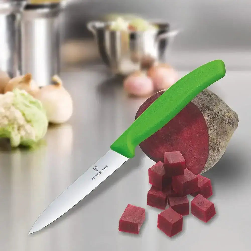 Green-handled knife with diced beetroot on a kitchen counter