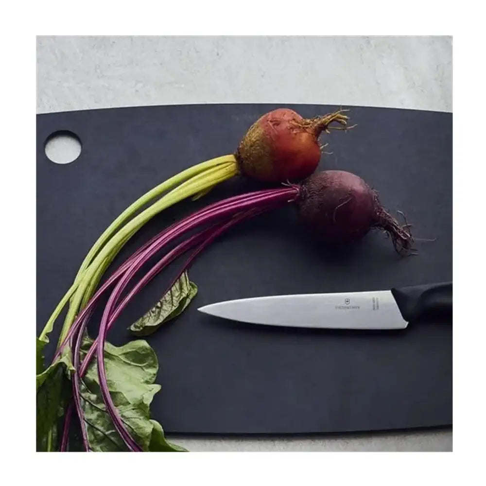 Beets with a knife on a dark cutting board