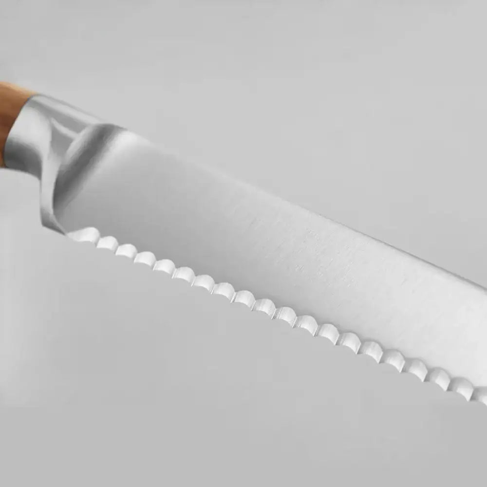 Close-up of a serrated knife blade on a white background