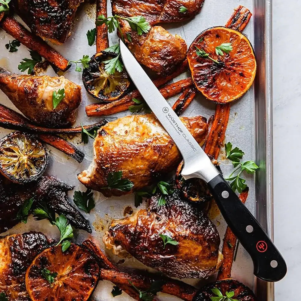Roasted chicken and vegetables on a baking tray with a knife
