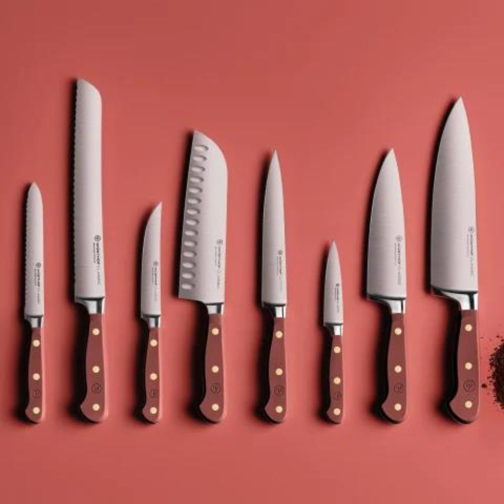 Set of knives with brown handles on a red background