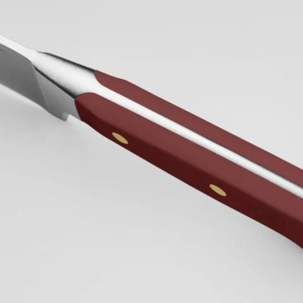 Close-up of a knife with a red handle on a light gray background