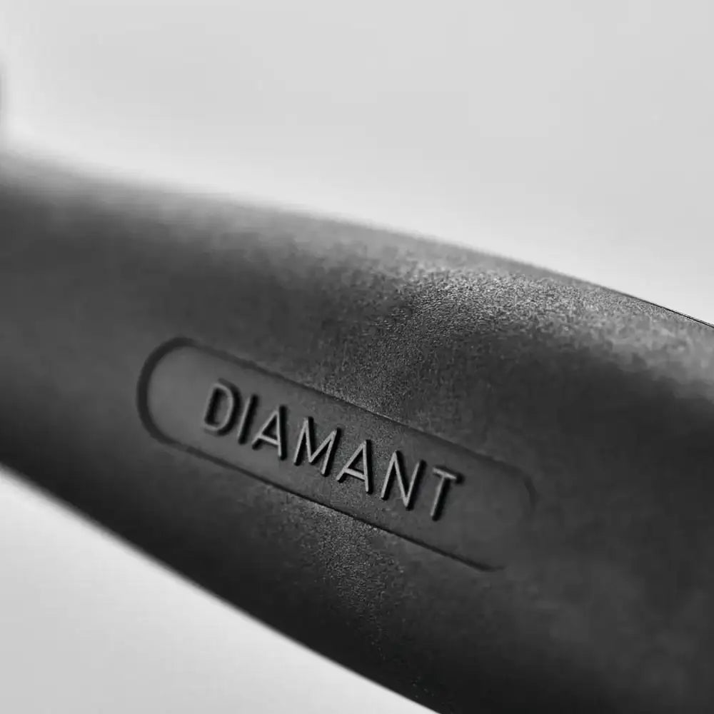 Close-up of a black object with 'DIAMANT' branding on a light gray background
