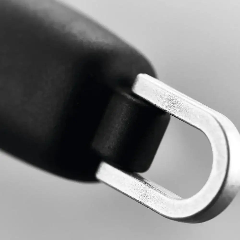Close-up of a hand holding a metallic carabiner against a neutral background