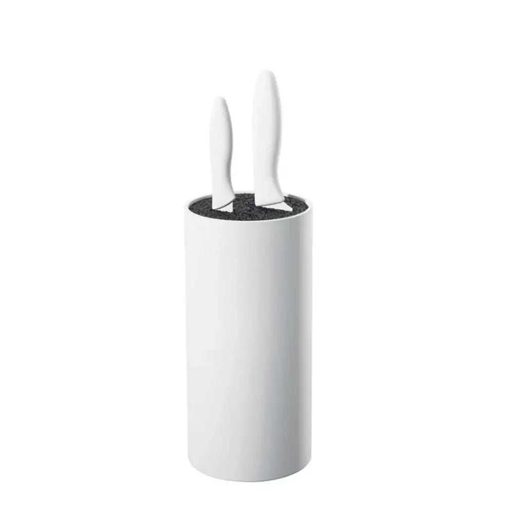 White cylindrical container with black interior holding two white knives on a white background