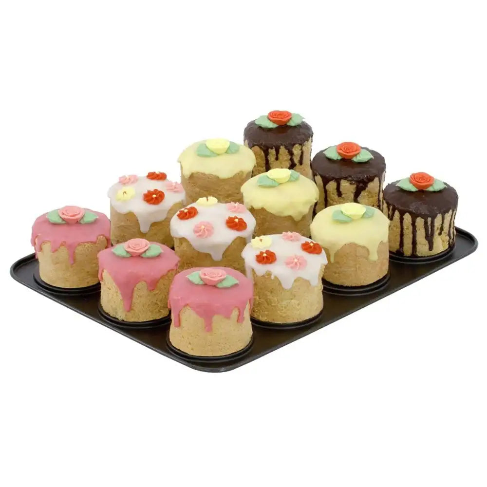 Assorted mini decorated cakes on a black tray with a white background