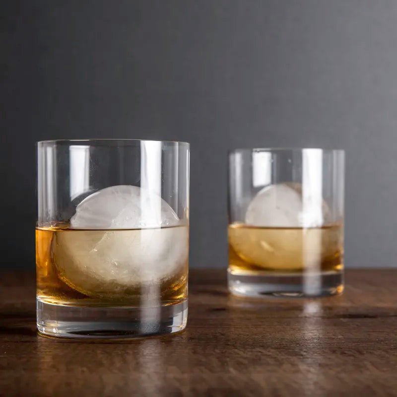 Two glasses with ice cubes and a dark background