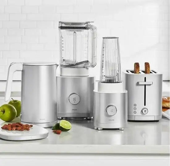 Set of kitchen appliances including a blender, toaster, and juicer on a white countertop.