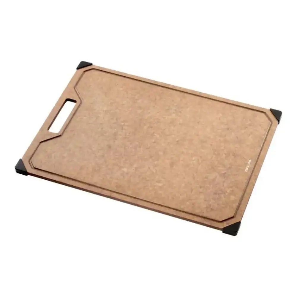 Large rectangular brown wood fiber cutting board with juice groove and black corner grips