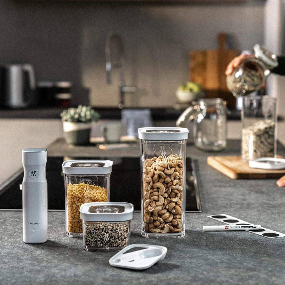 Set of kitchen storage containers on a countertop with a blurred kitchen background