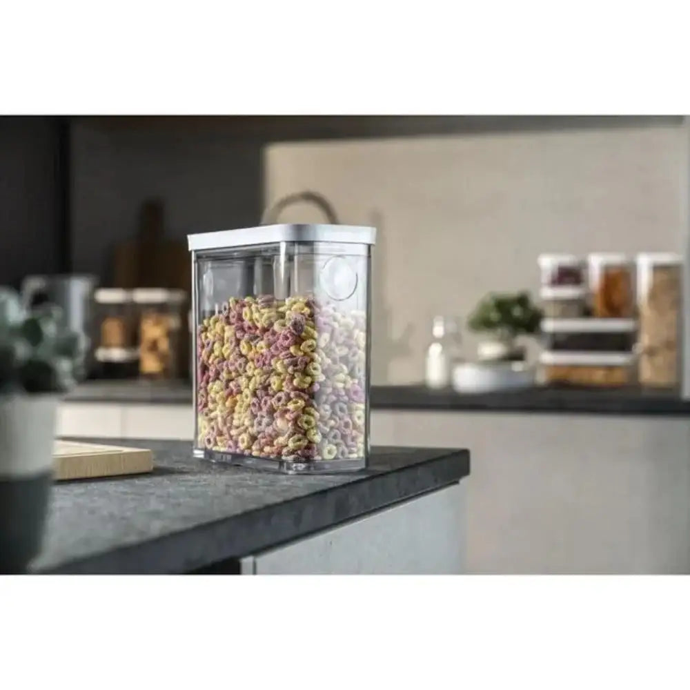Clear storage container with colorful cereal on a kitchen counter