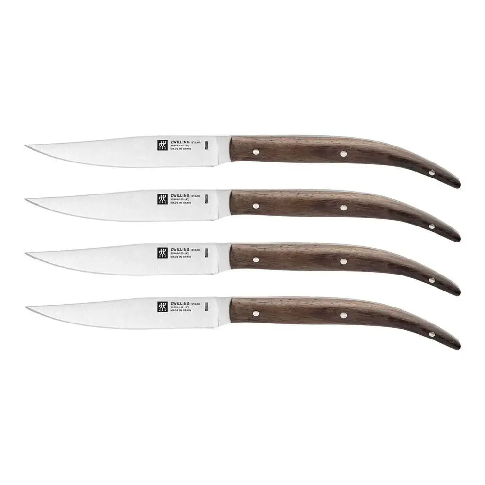 Set of four steak knives with wooden handles on a white background