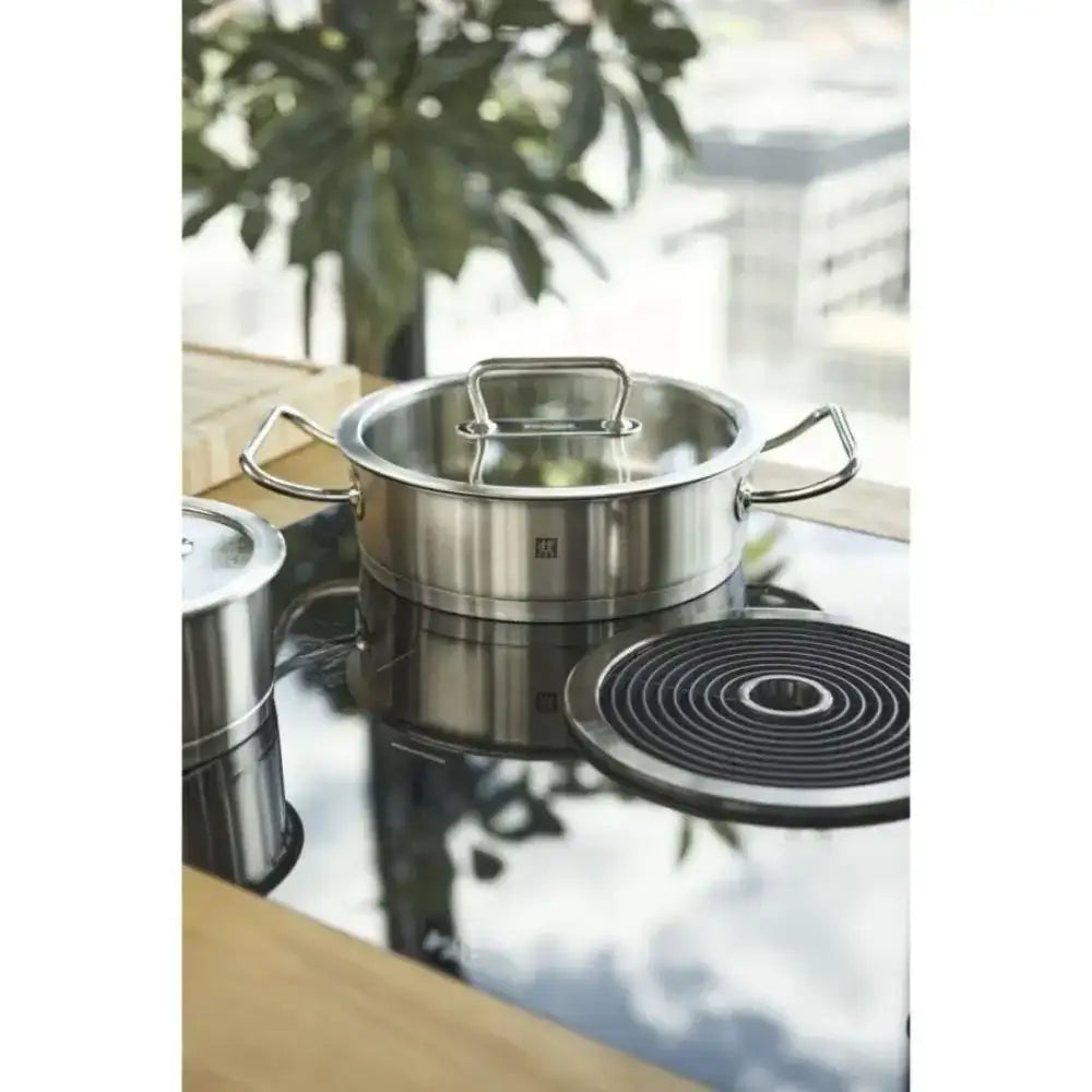 Stainless steel pot on a modern kitchen stove with a blurred background