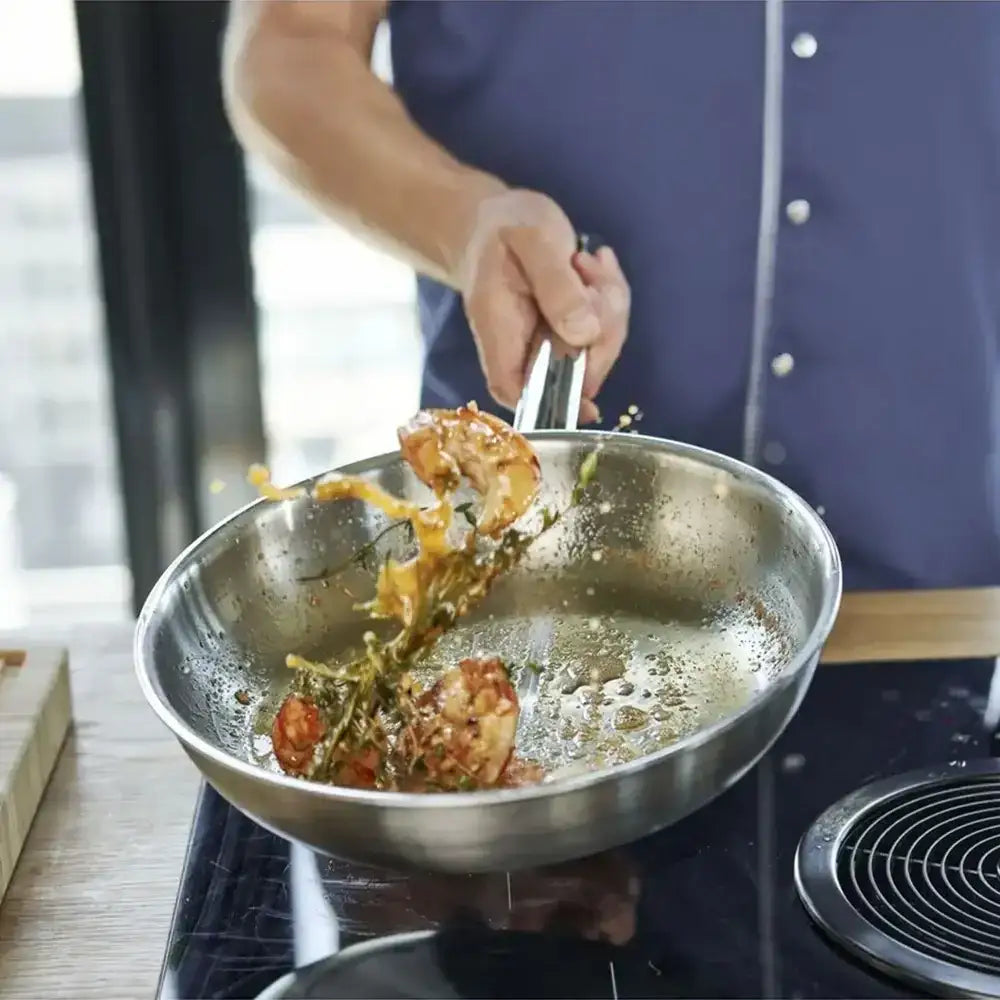 Person cooking food in a frying pan on a stove