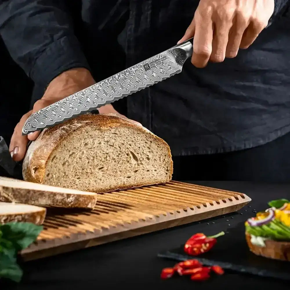 Person slicing bread with a knife on a wooden cutting board, with vegetables in the background.