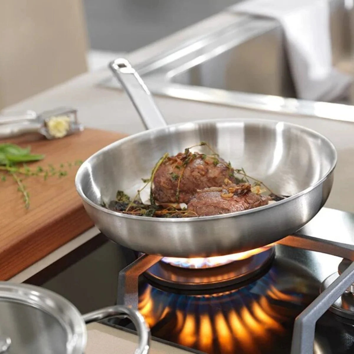 zwilling stainless steel frying pan, on a gas stove searing meat