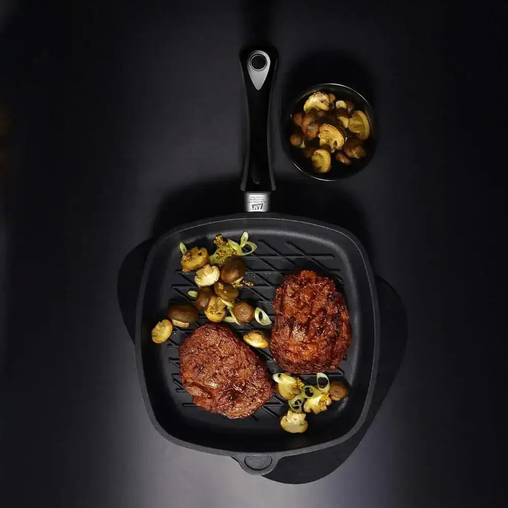 AMT non-stick square BBQ grill pan with grilled steaks and mushrooms on black background