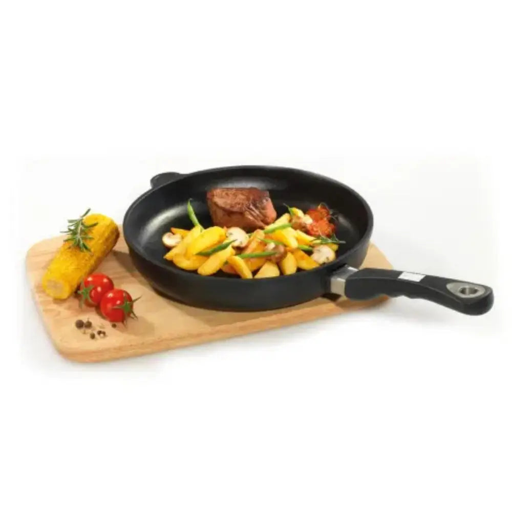 Black frying pan with food on a wooden cutting board on a white background