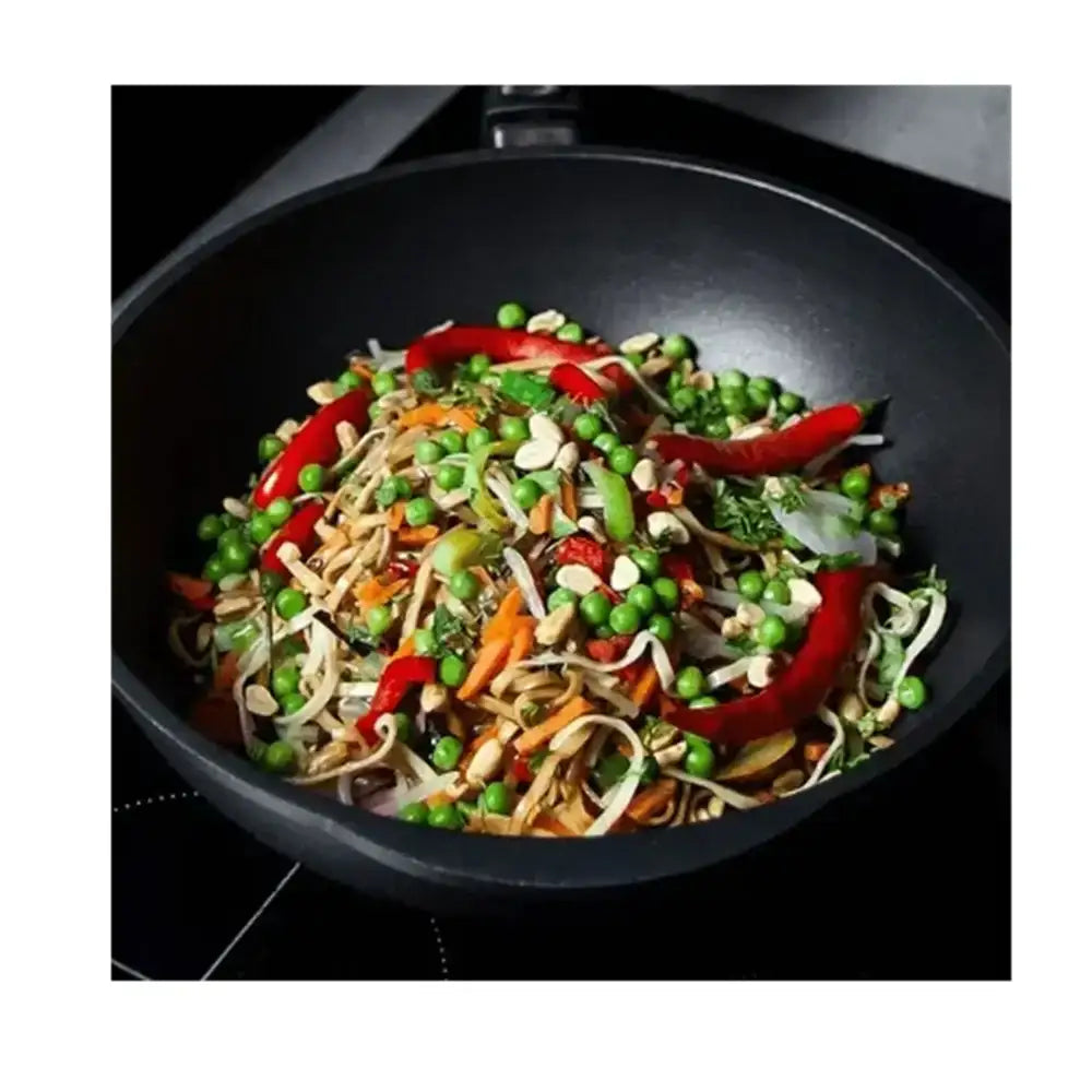 Wok with stir-fried vegetables and noodles on a white background