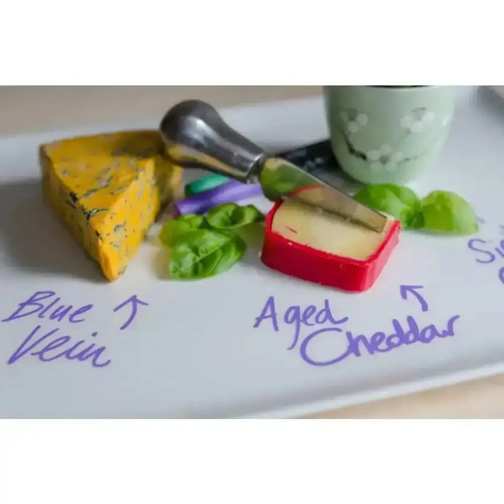 Two types of cheese on a plate with descriptive text and a knife.