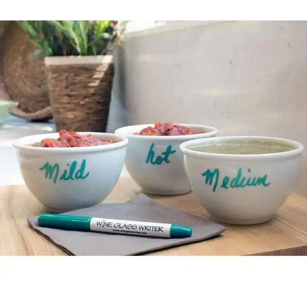 Three white bowls labeled 'Mild', 'Hot', and 'Medium' with a marker on a wooden surface.